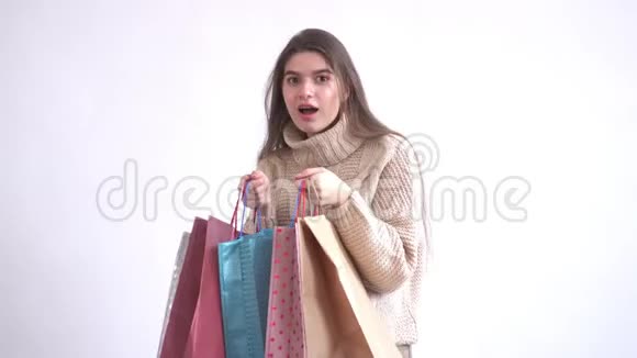 一位性格开朗快乐的女士带粉色背景的多色套装购物视频的预览图