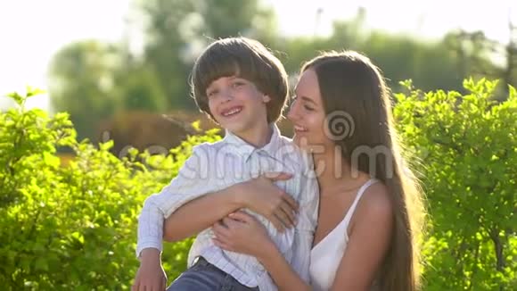 家庭在户外快乐母子小男孩微笑着拥抱在阳光明媚的夏天享受大自然母亲和儿童视频的预览图