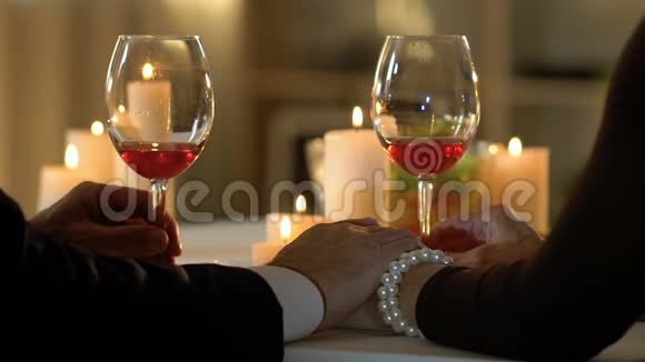 夫妻在浪漫的夜晚喝酒男人牵着女人的手爱信任视频的预览图