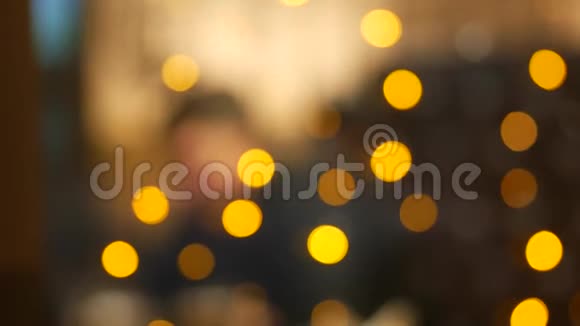 黄色的节日灯咖啡客在餐桌上模糊的轮廓视频的预览图