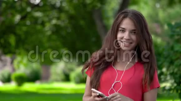 一个漂亮的年轻女子戴着耳机听着音乐的特写镜头她正在走向曲调她很放松视频的预览图