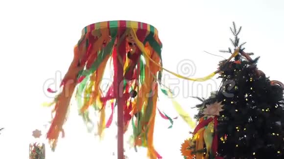 攀爬马斯莱尼萨的节日木杆阳光穿过在风中飘动的明亮丝带视频的预览图