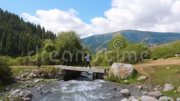 在吉尔吉斯斯坦天山山上的桥上行走时使用智能手机导航的游客视频的预览图