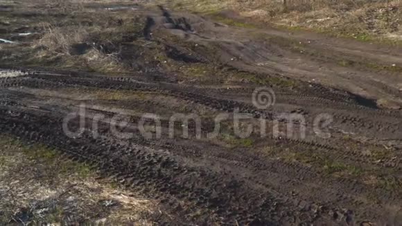 泥泞的土路和水坑穿过田野视频的预览图