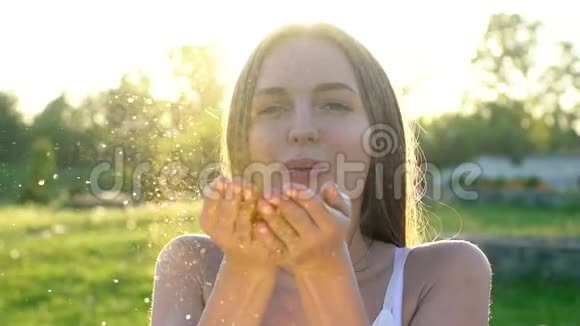 性感女人美丽的女人在户外缓慢地吹着纸屑白种人快乐的少女与金色闪光视频的预览图