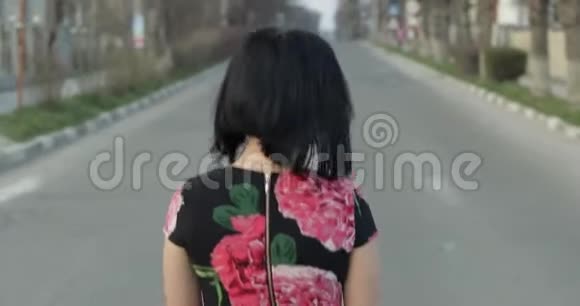一位漂亮的年轻女子穿着一着鲜花的连衣裙转过身来微笑着视频的预览图