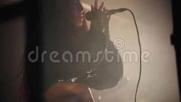 一位女歌手在烟雾弥漫的舞台上有感情地唱歌视频的预览图