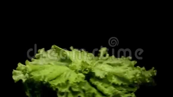关闭一堆新鲜的绿色沙拉旋转隔离在黑色背景库存录像绿色沙拉叶视频的预览图