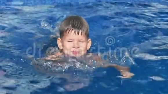 可爱的欧洲小男孩在游泳池里玩耍和漂浮视频的预览图