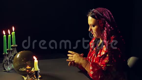 一个吉普赛人在烛光下在算命的沙龙里洗牌算命视频的预览图