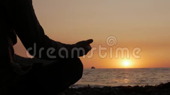日出时坐在海边沉思的人的剪影视频的预览图