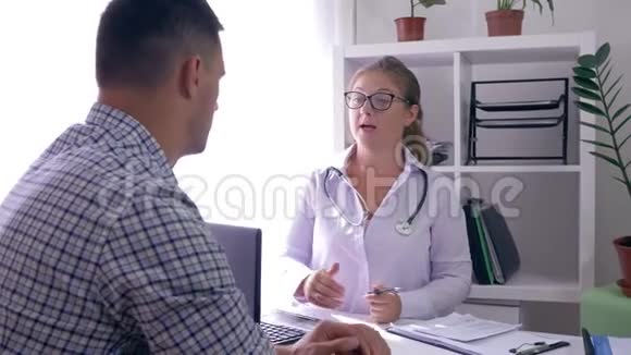 医生告诉病人坐在医疗室的桌子旁的健康状况视频的预览图
