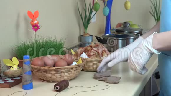 女人手准备用洋葱壳厨房染色的复活节彩蛋4K视频的预览图