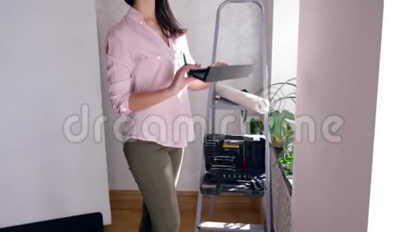 幸福的年轻女性在修理新公寓时会装饰内部并挂在墙上视频的预览图