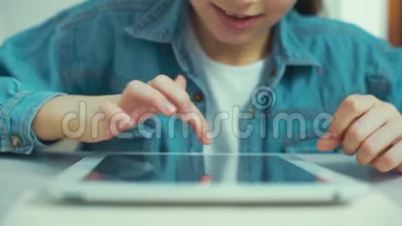 穿牛仔裤的小女孩穿着平板电脑玩游戏视频的预览图