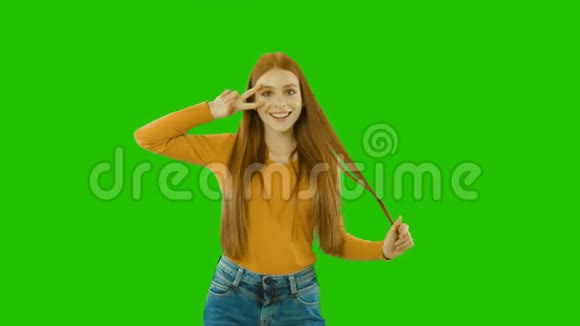 可爱的年轻红发少女一只手握着两根手指靠近她的眼睛视频的预览图