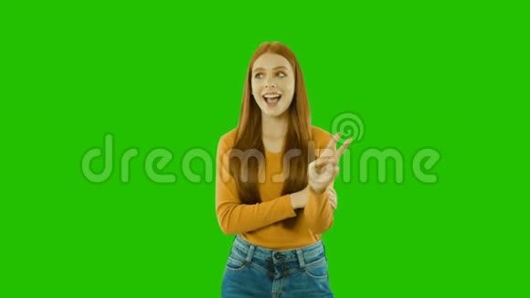 迷人的红色长发充满感情地微笑着用一只手展示她然后用另一只交替的手和视频的预览图