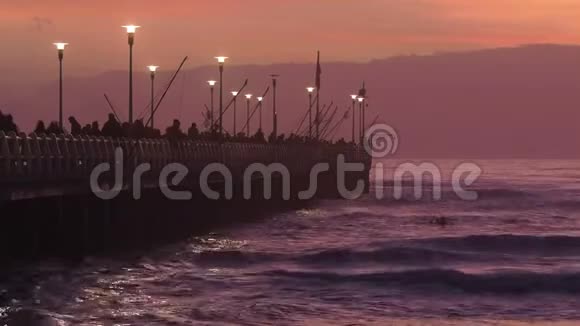 日落时分人们在马尔米码头散步和钓鱼视频的预览图