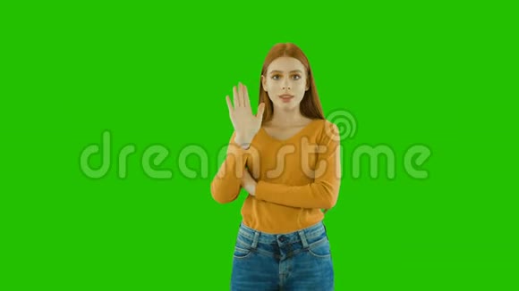 一个年轻漂亮的女孩留着一头红色的长发用手势表示停止视频的预览图