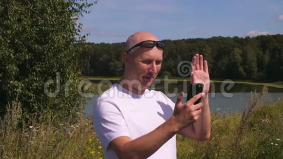 一个男人在电话里打视频聊天时挥舞着大拇指视频的预览图