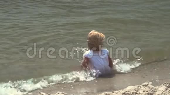 一个小女孩在海里洗澡孩子坐在海里视频的预览图