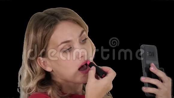 美丽时尚的年轻女性嘴唇上涂着红色口红看着手机屏幕阿尔法频道视频的预览图