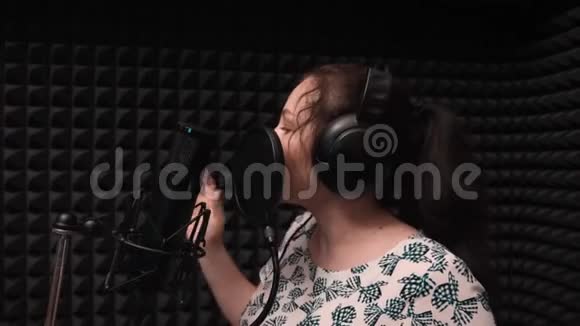 年轻的浪漫女歌手在录音室有感情地唱歌音乐排练视频的预览图