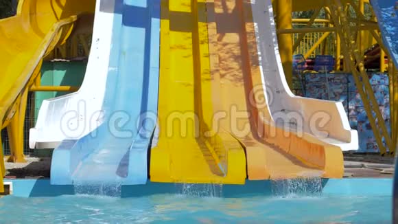 夏天在水上乐园玩勇敢的女孩滑下滑水道跳进游泳池与飞溅视频的预览图