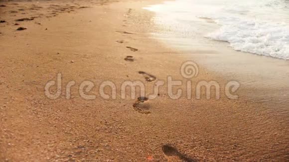 沙滩上海浪冲刷脚印的慢镜头视频的预览图