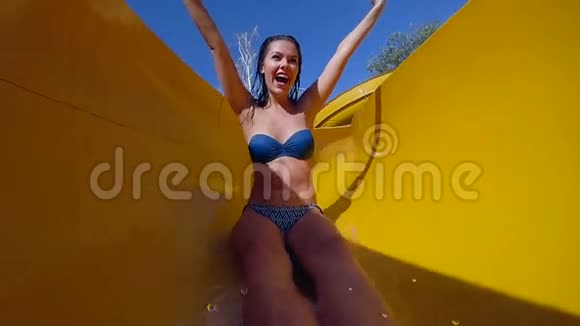 情绪开朗的女孩穿上泳衣双手举起来在水上公园的特写镜头中在明亮的阳光下度假视频的预览图