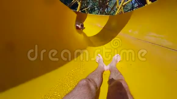 周末在水上公园里男人沿着彩色的水滑道追上前面的女孩溅起水花视频的预览图