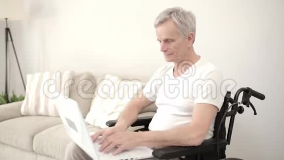 灰头土脸的男人坐在他的病房里的轮椅上坐在笔记本电脑前视频的预览图