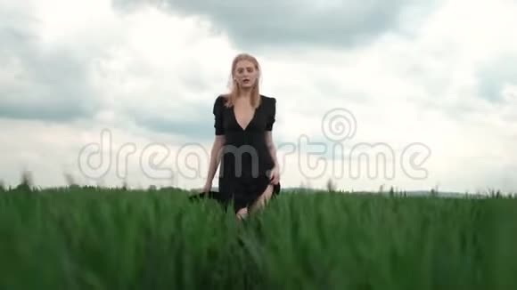 穿着黑色衣服的女孩跑过田野金发的浪漫形象视频的预览图