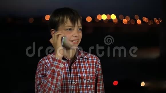 小帅哥8岁晚上在城里用手机说话男孩说智能手机笑得很开心视频的预览图