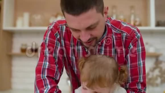 可爱的小女孩和她父亲一起做饼干视频的预览图