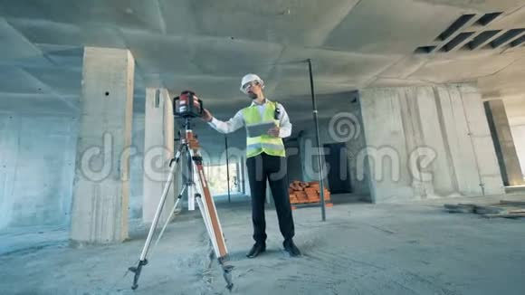 建筑工人在一个建筑工地调节土地测量设备视频的预览图
