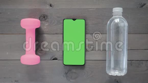 绿色屏幕一个智能手机水瓶和桌子上的哑铃视频的预览图