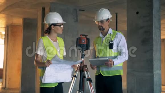 一名男工程师和一名女工程师正在大楼里讨论视频的预览图