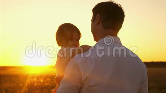 爸爸和小孩子一起散步在傍晚的公园里日落时分爸爸和女儿一起放假一天视频的预览图