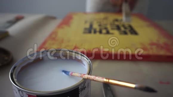 这位艺术家把刷子浸入罐子里用清漆覆盖图片油漆罐你这个胆小鬼手工艺视频的预览图