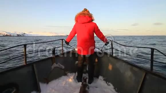 穿红色夹克的人在船头视频的预览图