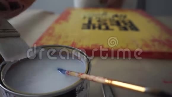 这位艺术家把刷子浸入罐子里用清漆覆盖图片油漆罐你这个胆小鬼手工艺视频的预览图