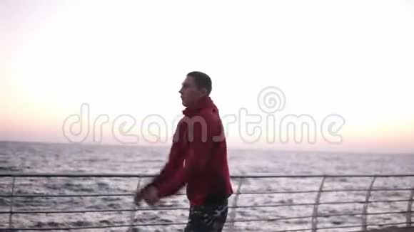 年轻的白种人男拳击手伸展手臂在海边的户外热身体育拳击概念视频的预览图