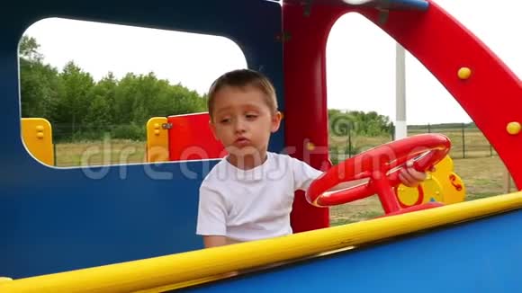 幼儿的情绪这个男孩坐在操场上的木车里玩视频的预览图