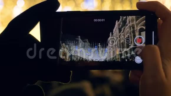 在智能手机上拍摄视频圣诞照明和广场上的许多人视频的预览图
