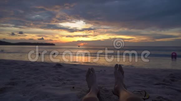 慢镜头一个人的腿在海滩上观看一个美妙的日落视频的预览图