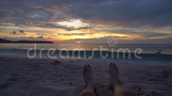 慢镜头一个女人的腿在海滩上观看一个美妙的日落视频的预览图