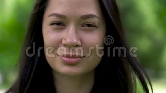 一幅可爱的亚洲女人用眼睛眨眼睛的肖像特写镜头视频的预览图