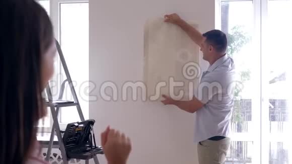 业主男性选择新的墙纸而女性则在家中决定修理视频的预览图