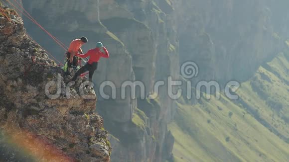 一群登山者在悬崖边讨论一项行动计划视频的预览图